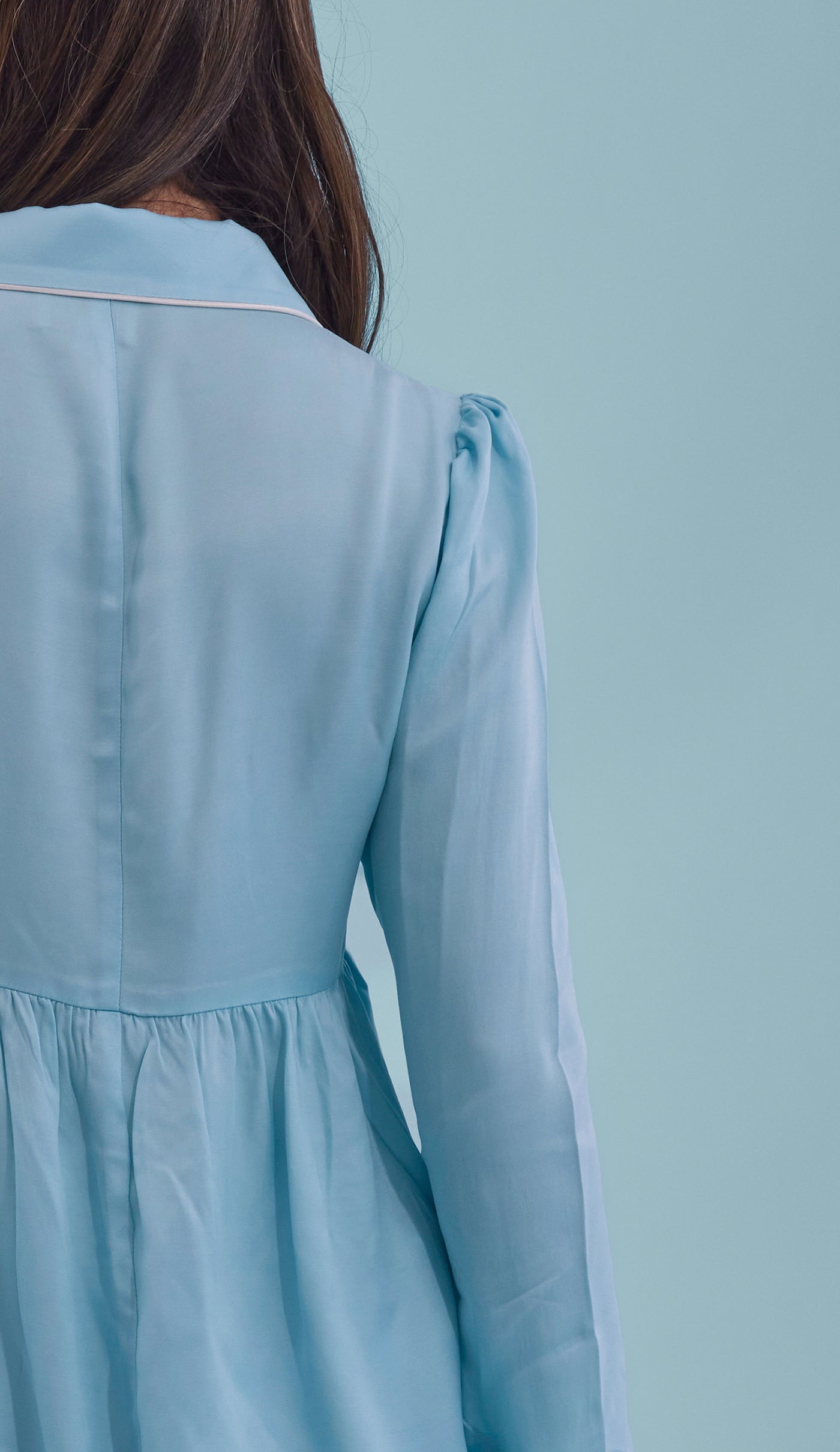 Close-up of ice blue PJ blouse with long sleeves on a light blue background